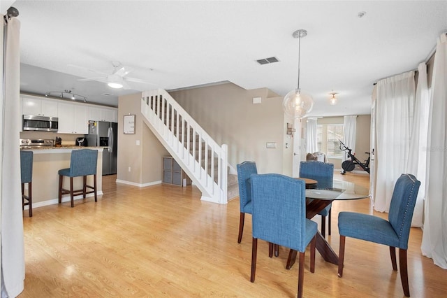 dining area with light hardwood / wood-style floors and ceiling fan