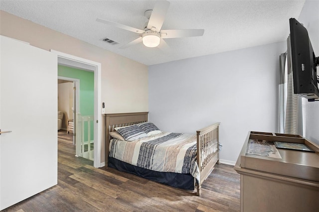 bedroom featuring a textured ceiling, ceiling fan, and dark hardwood / wood-style floors