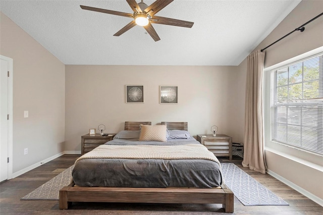 bedroom featuring a textured ceiling, vaulted ceiling, ceiling fan, and wood-type flooring