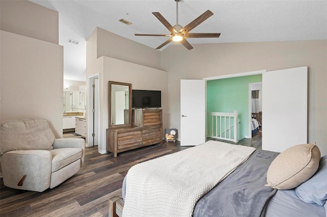 bedroom with ensuite bathroom, ceiling fan, vaulted ceiling, and dark hardwood / wood-style flooring