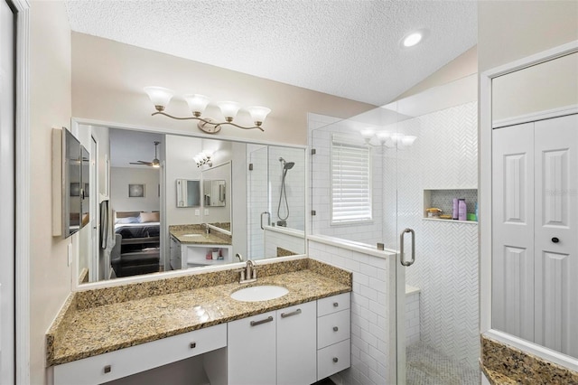 bathroom featuring vanity, an enclosed shower, a textured ceiling, and lofted ceiling