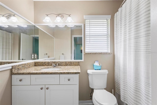 bathroom with walk in shower, vanity, and toilet