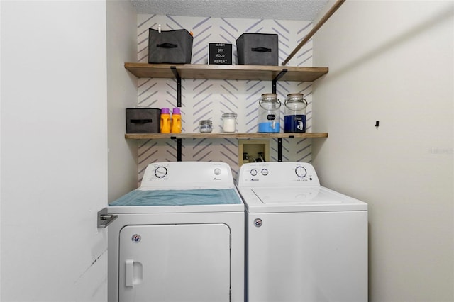 clothes washing area with a textured ceiling and independent washer and dryer