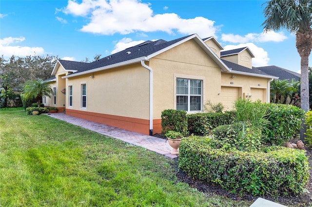 view of side of property featuring a garage and a lawn