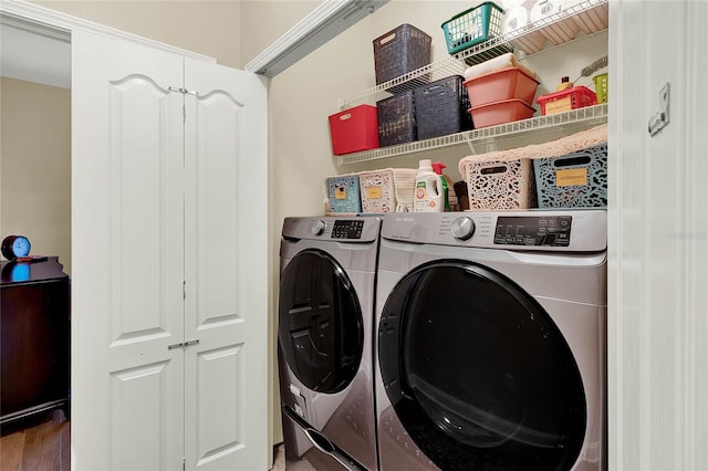 clothes washing area featuring separate washer and dryer and hardwood / wood-style flooring