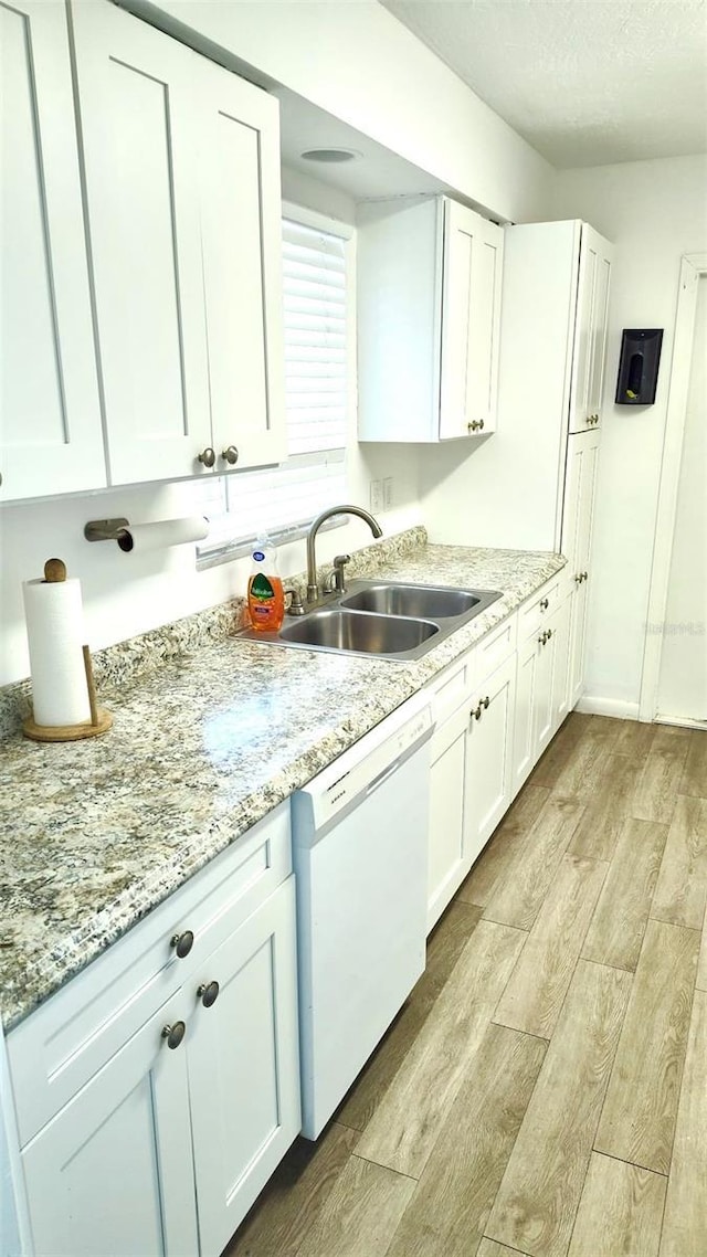 kitchen with white dishwasher and white cabinetry