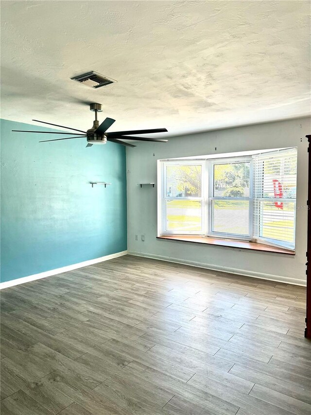 spare room featuring hardwood / wood-style floors, a textured ceiling, and ceiling fan