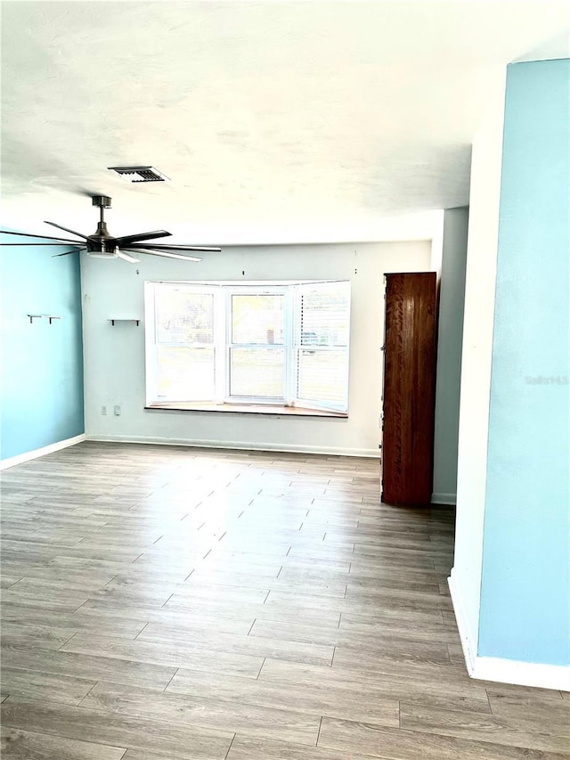 unfurnished room with ceiling fan and light wood-type flooring