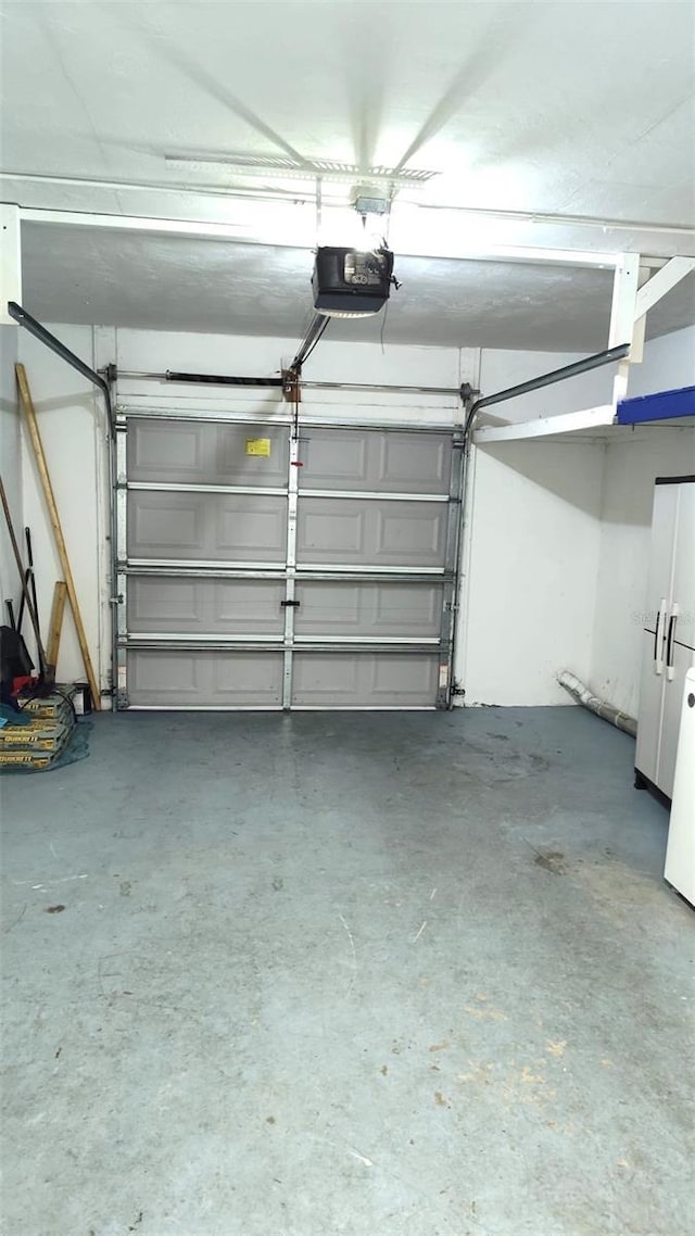 garage with a garage door opener and white refrigerator