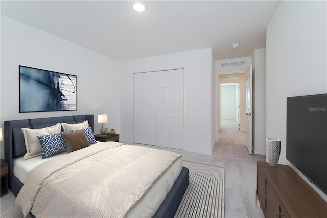 bedroom featuring light colored carpet and a closet