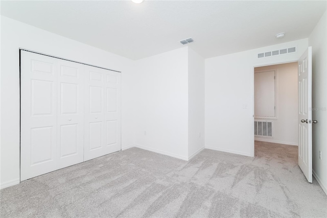 unfurnished bedroom with a closet and light carpet