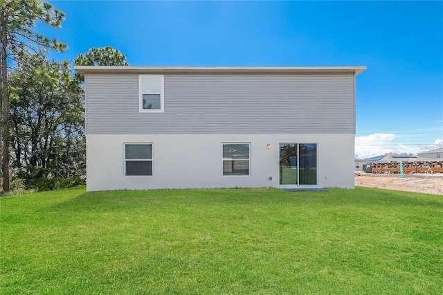 back of house featuring a lawn