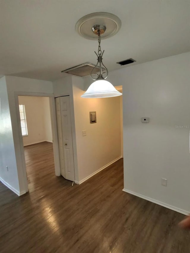 unfurnished dining area with dark wood-type flooring