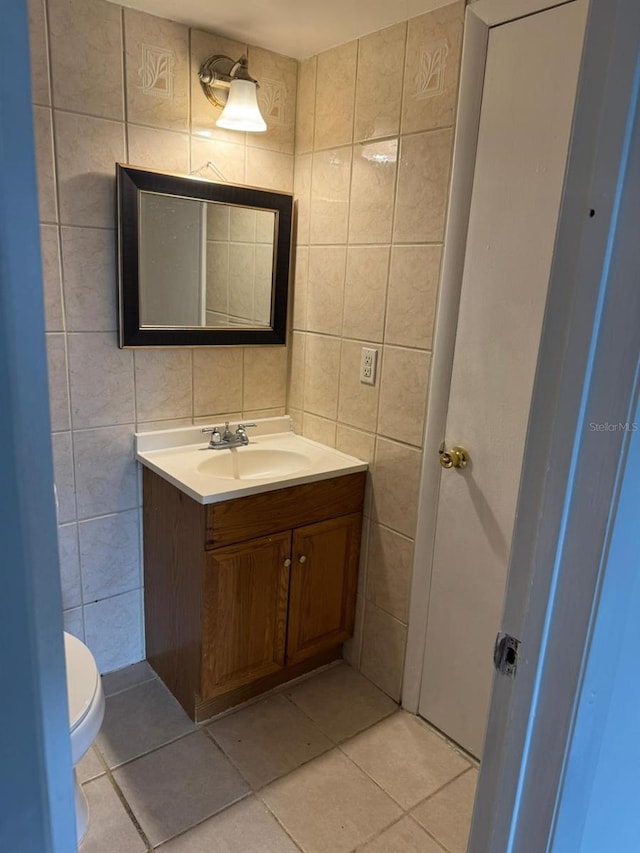 bathroom featuring tile walls, tile patterned floors, vanity, and toilet