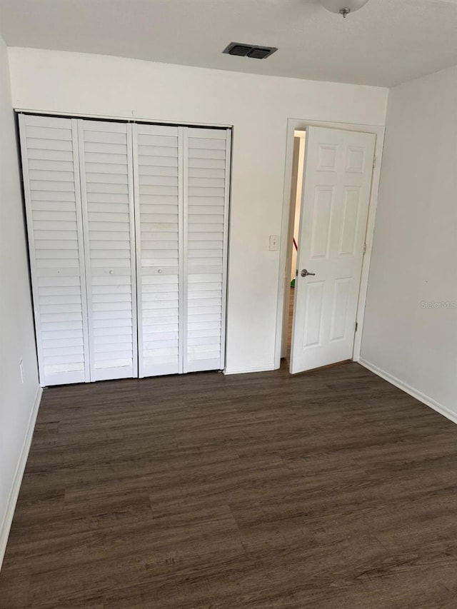 unfurnished bedroom with dark hardwood / wood-style flooring