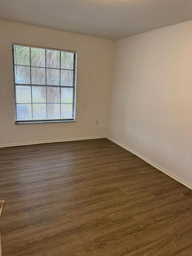 spare room with dark hardwood / wood-style flooring