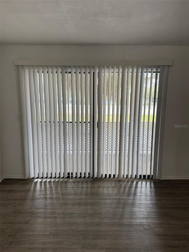 unfurnished room featuring a textured ceiling and dark hardwood / wood-style flooring