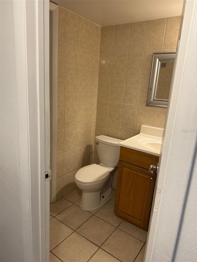 bathroom with tile patterned floors, tile walls, toilet, and vanity