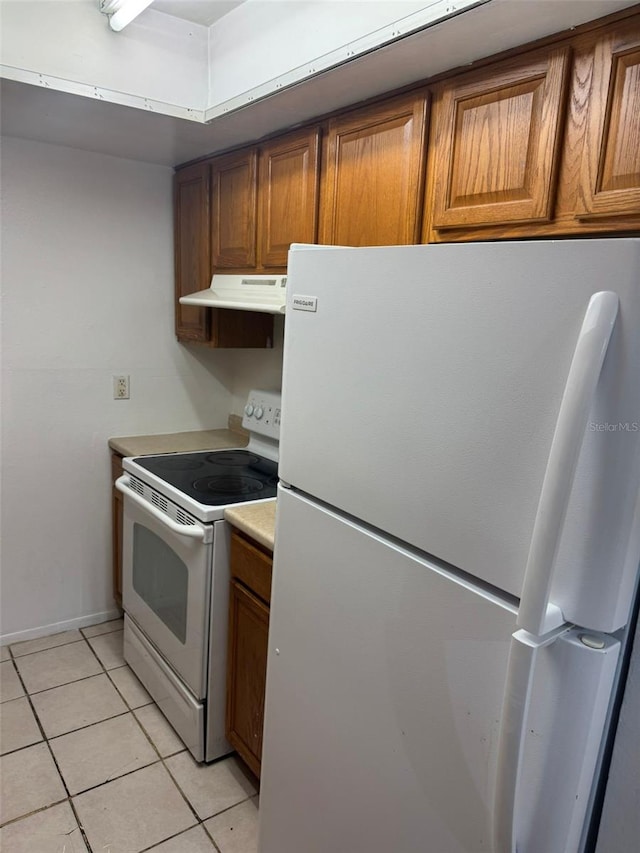 kitchen with white appliances and light tile patterned flooring