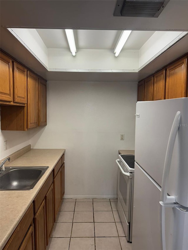 kitchen with sink, white appliances, and light tile patterned floors