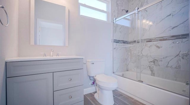 full bathroom featuring shower / bath combination with glass door, toilet, and vanity