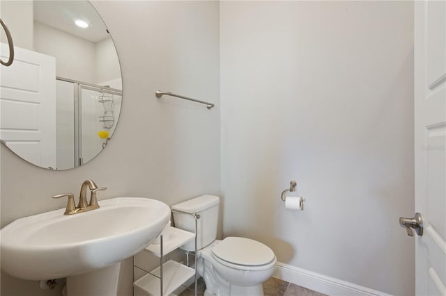 bathroom with tile patterned flooring, an enclosed shower, sink, and toilet