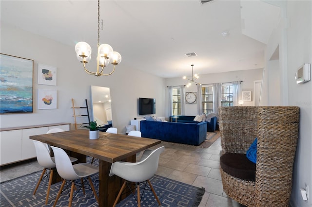 dining space with light tile patterned floors and a notable chandelier