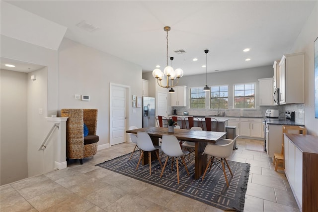 tiled dining room featuring a chandelier