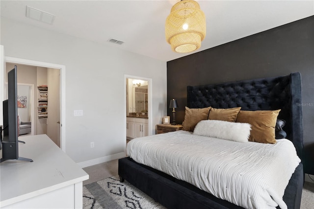 bedroom with light colored carpet and connected bathroom