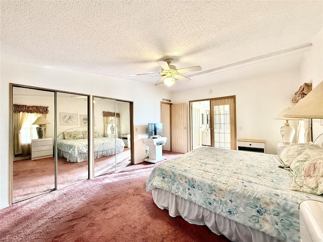 bedroom with a textured ceiling, multiple closets, ceiling fan, and carpet