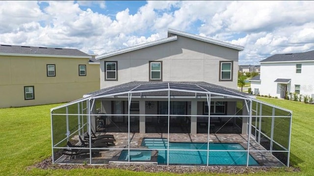 back of property with a patio area, a lawn, and a lanai