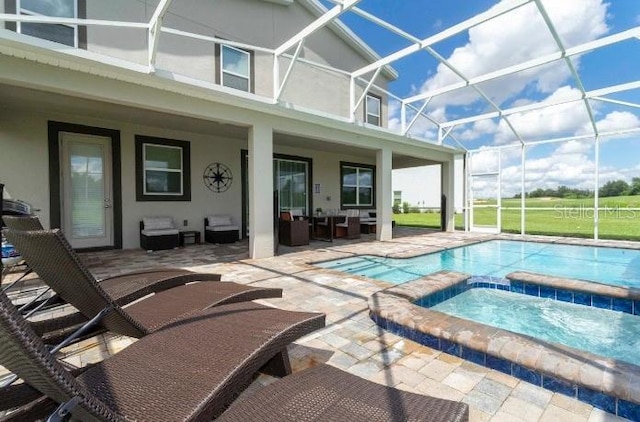 view of swimming pool featuring a lanai, a patio, and an in ground hot tub