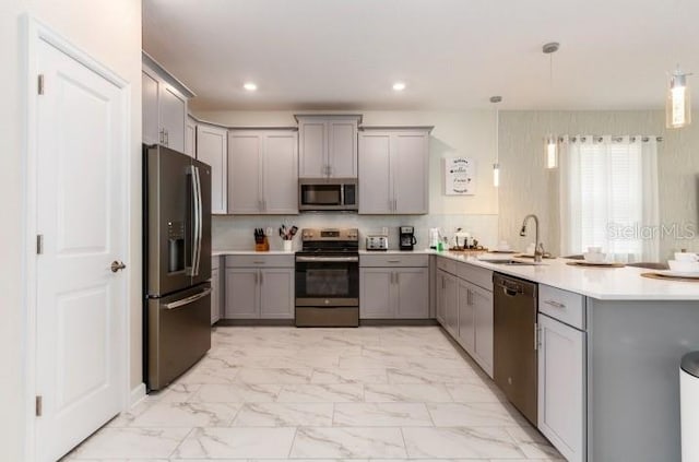 kitchen with gray cabinets, sink, appliances with stainless steel finishes, and decorative light fixtures