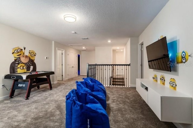 recreation room featuring a textured ceiling and carpet flooring