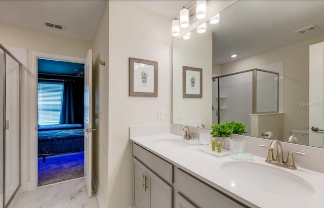 bathroom with an enclosed shower, vanity, and toilet