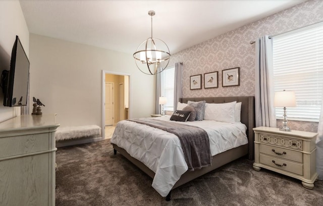 bedroom with dark colored carpet and a chandelier