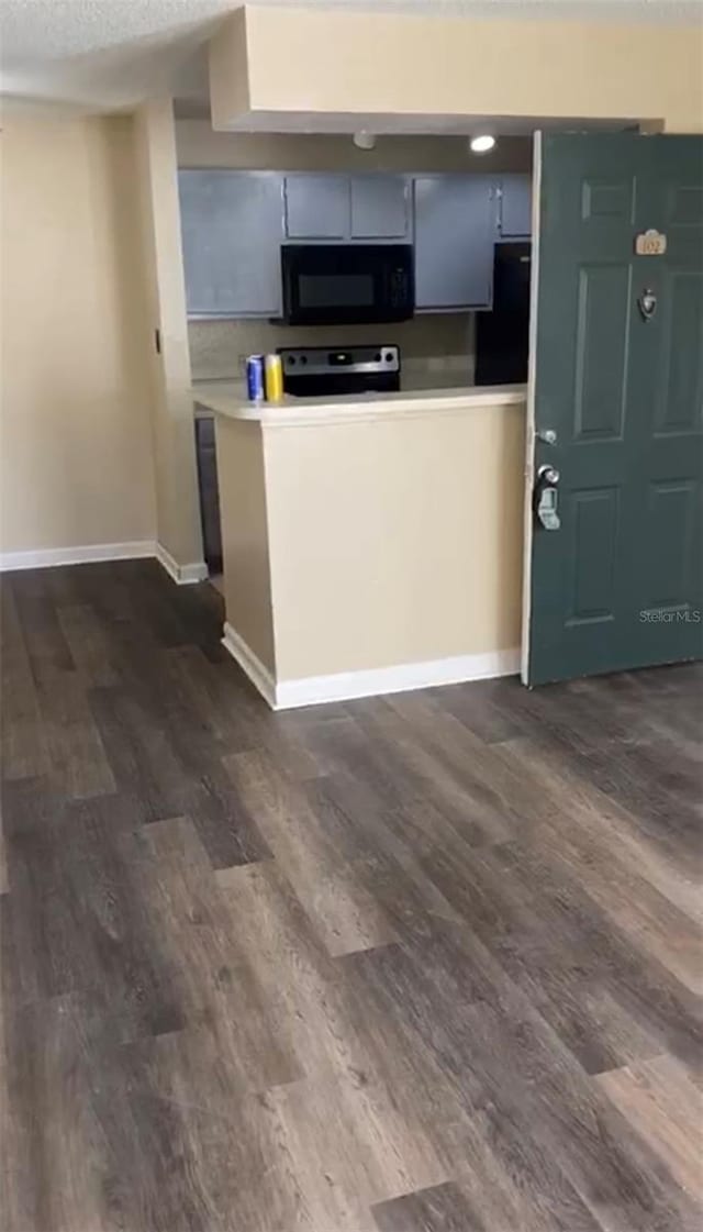 kitchen featuring a textured ceiling, range, and dark hardwood / wood-style flooring