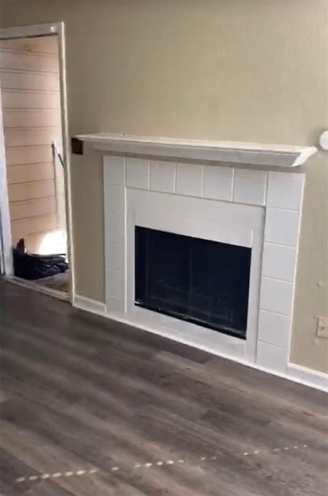 interior details with a tiled fireplace and hardwood / wood-style flooring