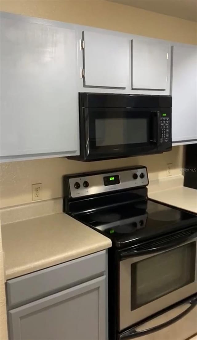 kitchen with white cabinets and stainless steel range with electric cooktop