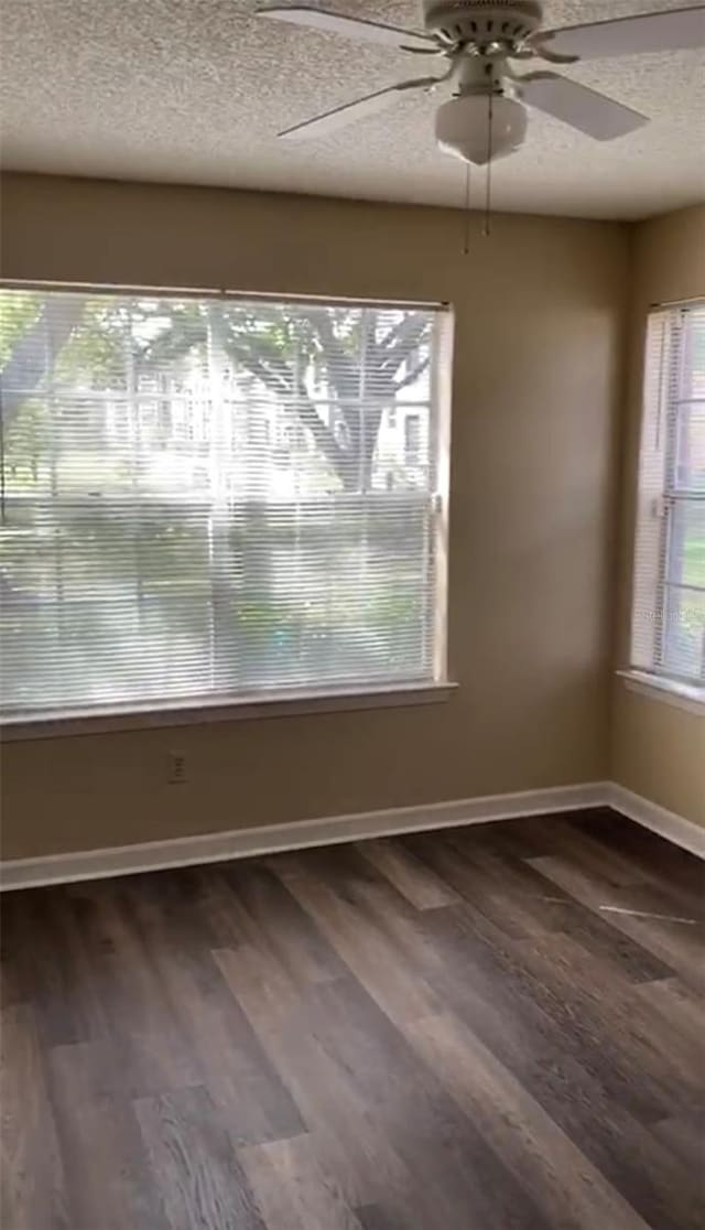 empty room with dark wood-type flooring, a textured ceiling, and ceiling fan