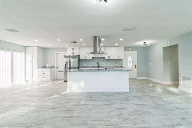 kitchen featuring island exhaust hood, sink, an island with sink, and white cabinets