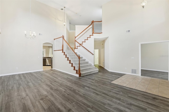 unfurnished living room featuring a high ceiling and dark hardwood / wood-style flooring