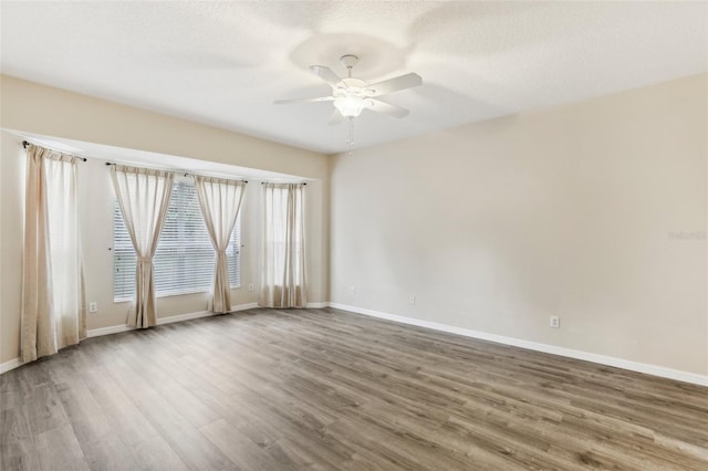 spare room with a textured ceiling, hardwood / wood-style flooring, and ceiling fan