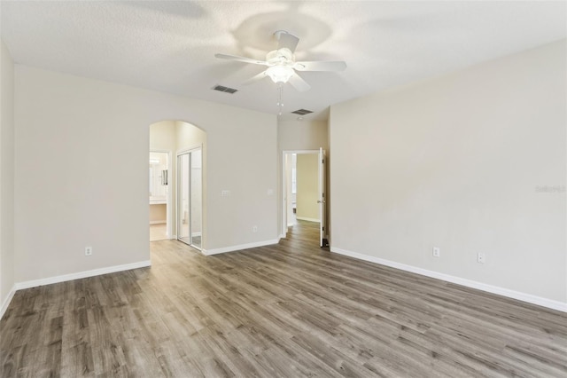 unfurnished room with hardwood / wood-style flooring, ceiling fan, and a textured ceiling