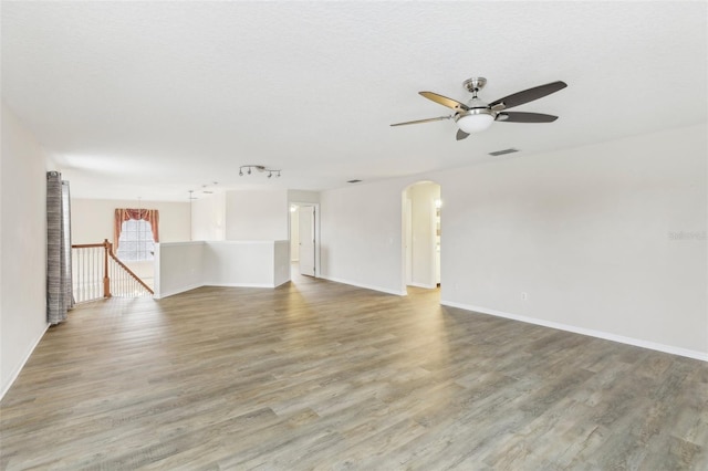 unfurnished room featuring hardwood / wood-style flooring, ceiling fan, and a textured ceiling