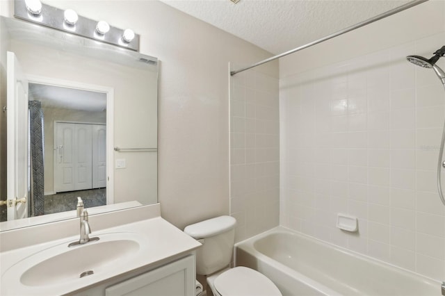 full bathroom with vanity, a textured ceiling, toilet, and tiled shower / bath