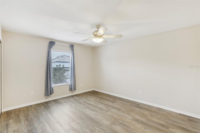 spare room featuring hardwood / wood-style flooring, ceiling fan, and a textured ceiling