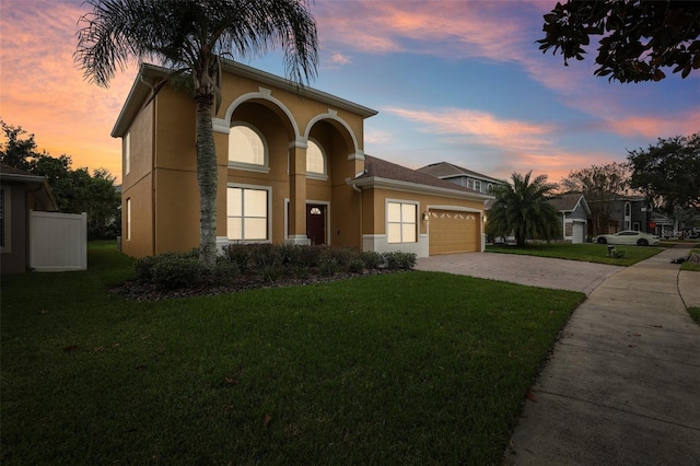 view of front of house with a garage and a lawn