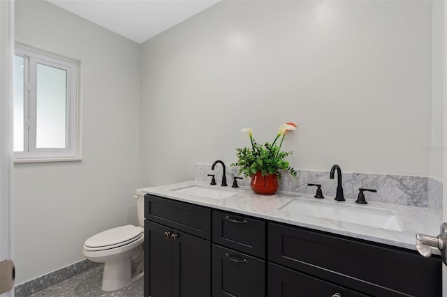 full bathroom with toilet, double vanity, and a sink