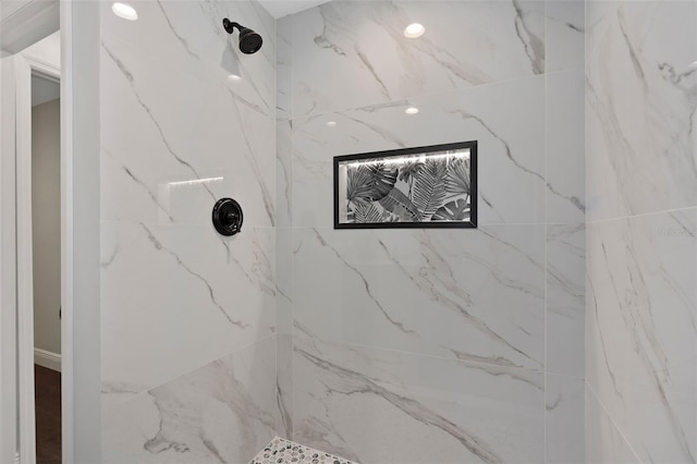 bathroom featuring a marble finish shower